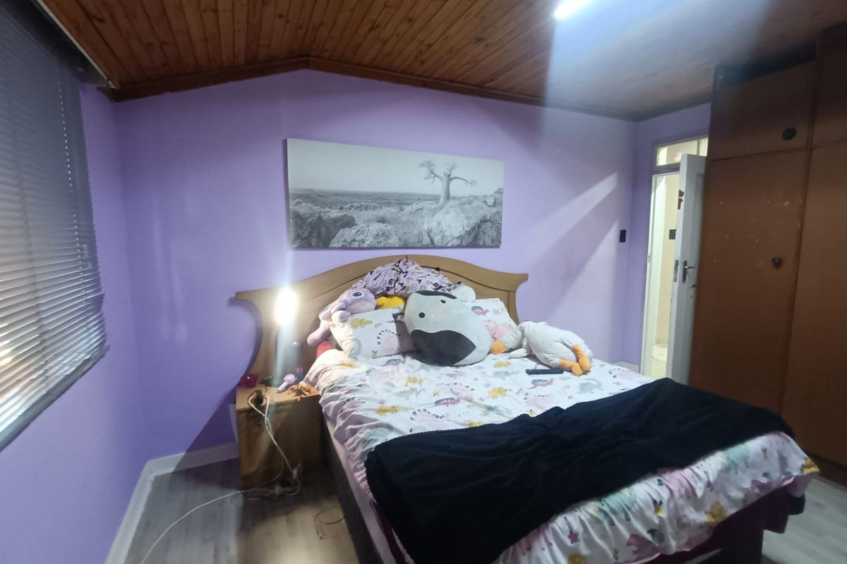 A bedroom featuring a timber-clad vaulted ceiling, laminate flooring, and built-in wardrobe storage.