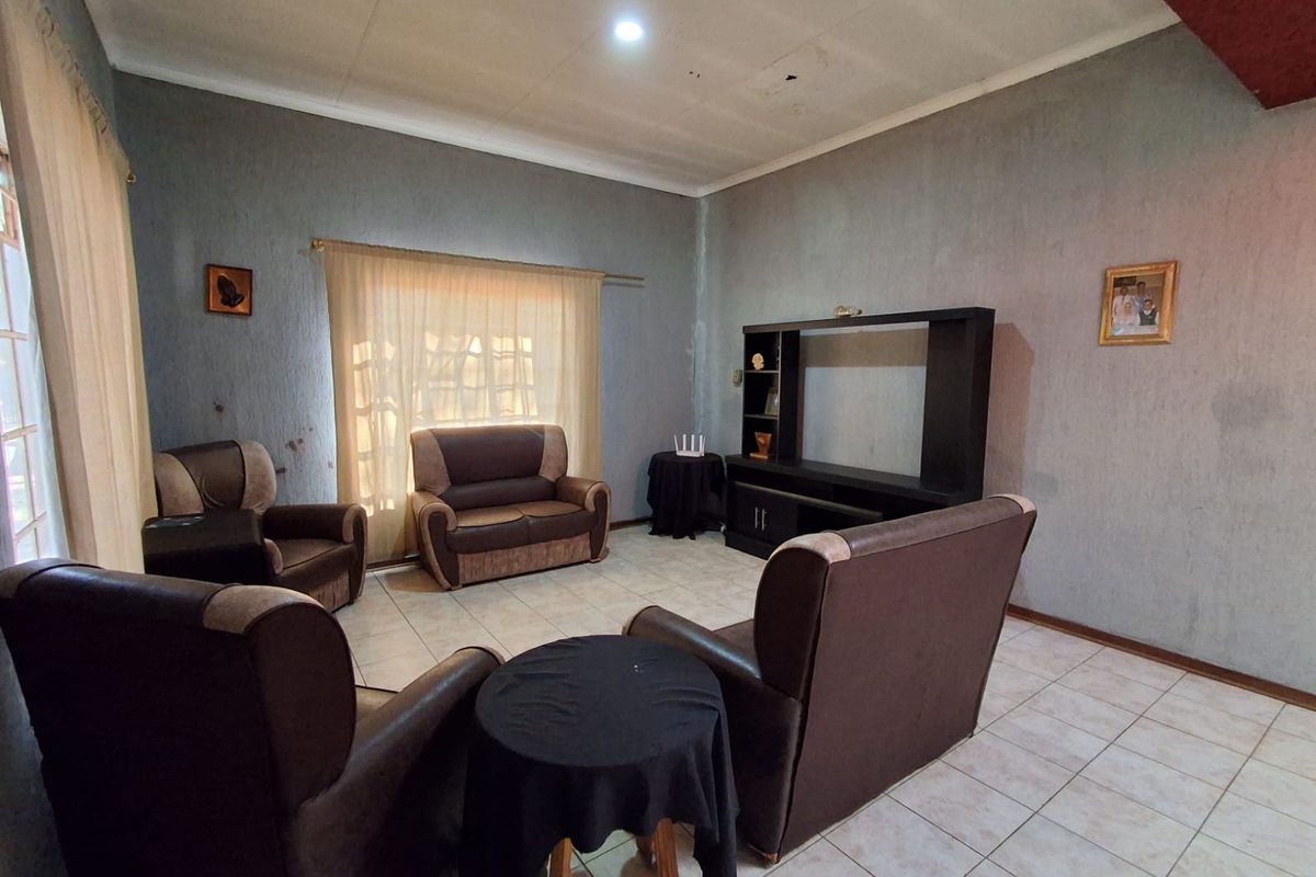 A living room featuring tiled flooring and a built-in media unit, requiring cosmetic updates to the walls and ceiling to enhance the space.