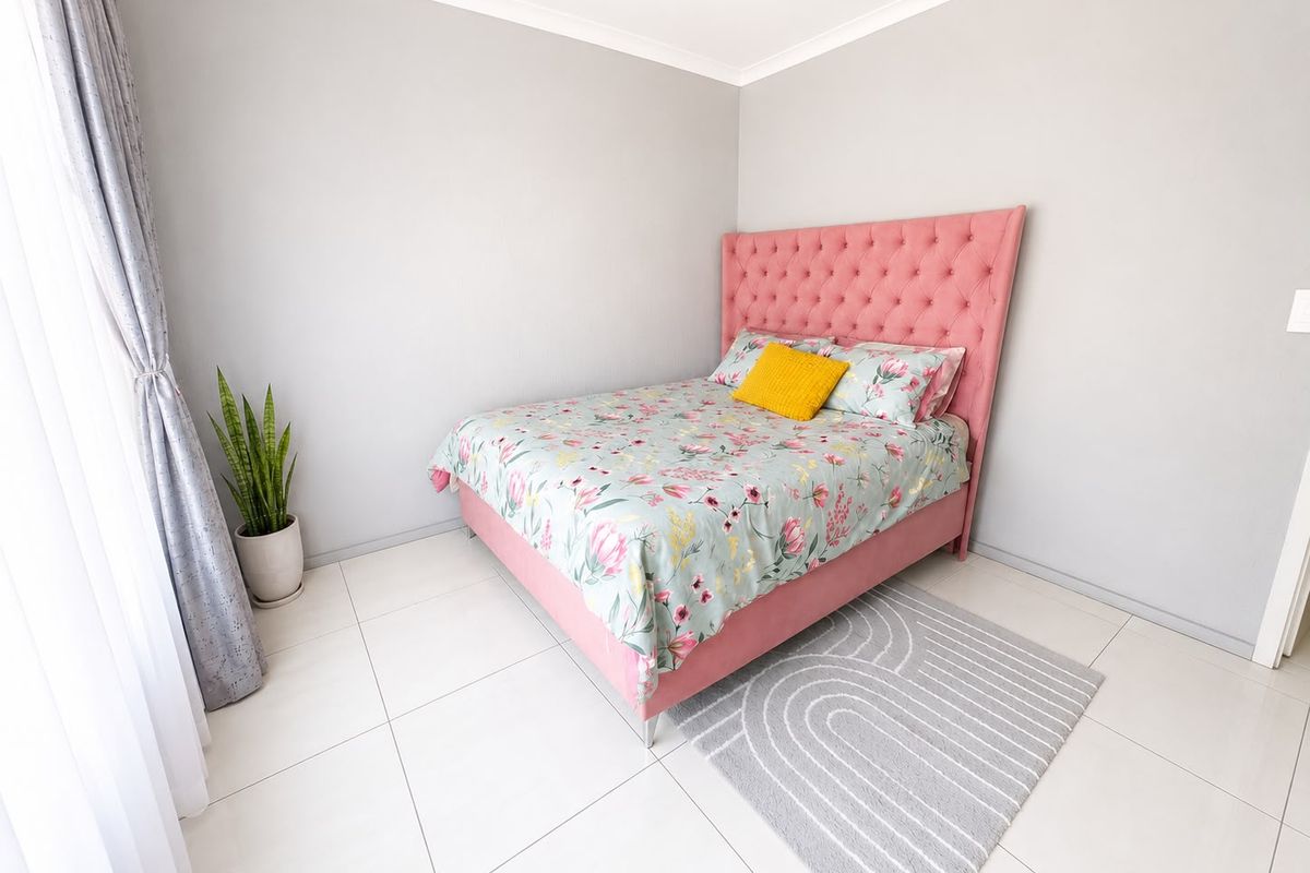 A bright and well-maintained bedroom featuring neutral wall tones, tiled flooring, and coved ceiling details.