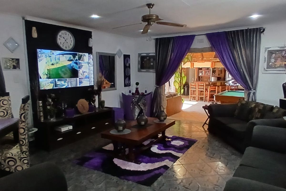 Spacious living room featuring tiled flooring, recessed lighting, and a ceiling fan, with an open transition to an adjacent entertainment area.