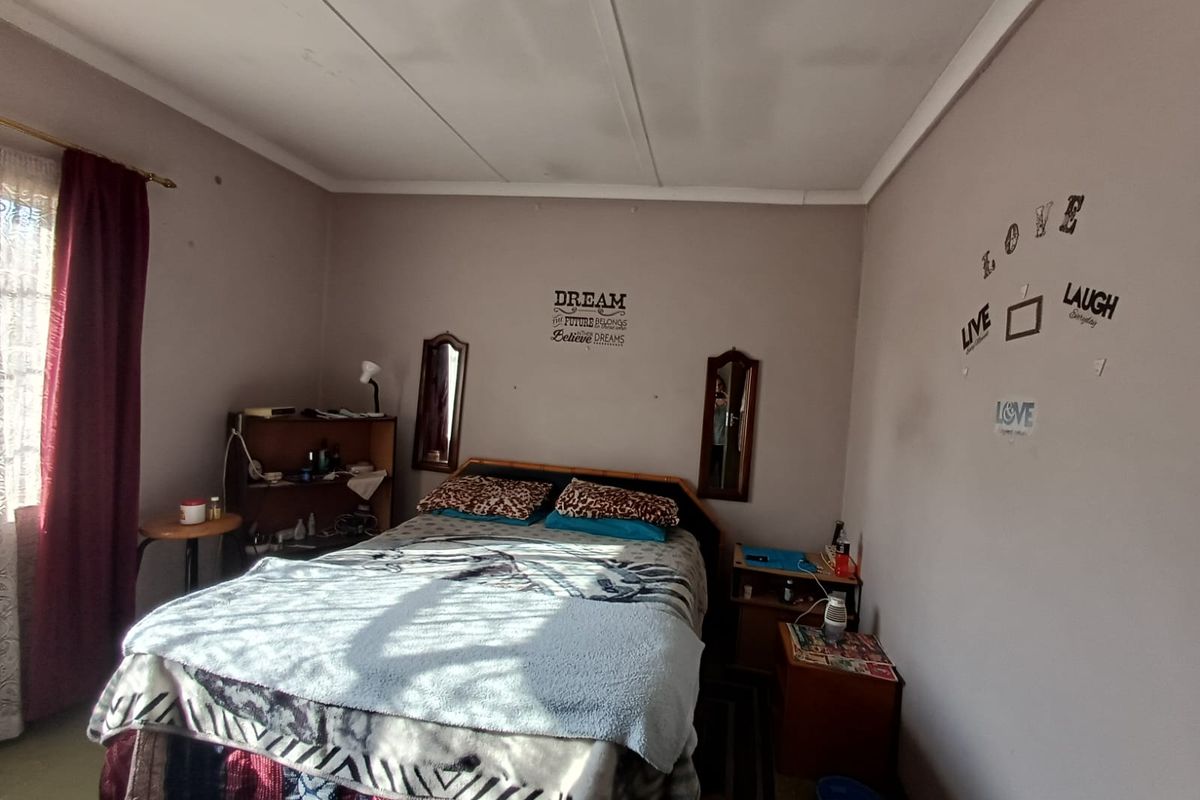A bedroom featuring standard ceiling tiles and neutral wall paint, offering a functional space ready for cosmetic updates and personalization.