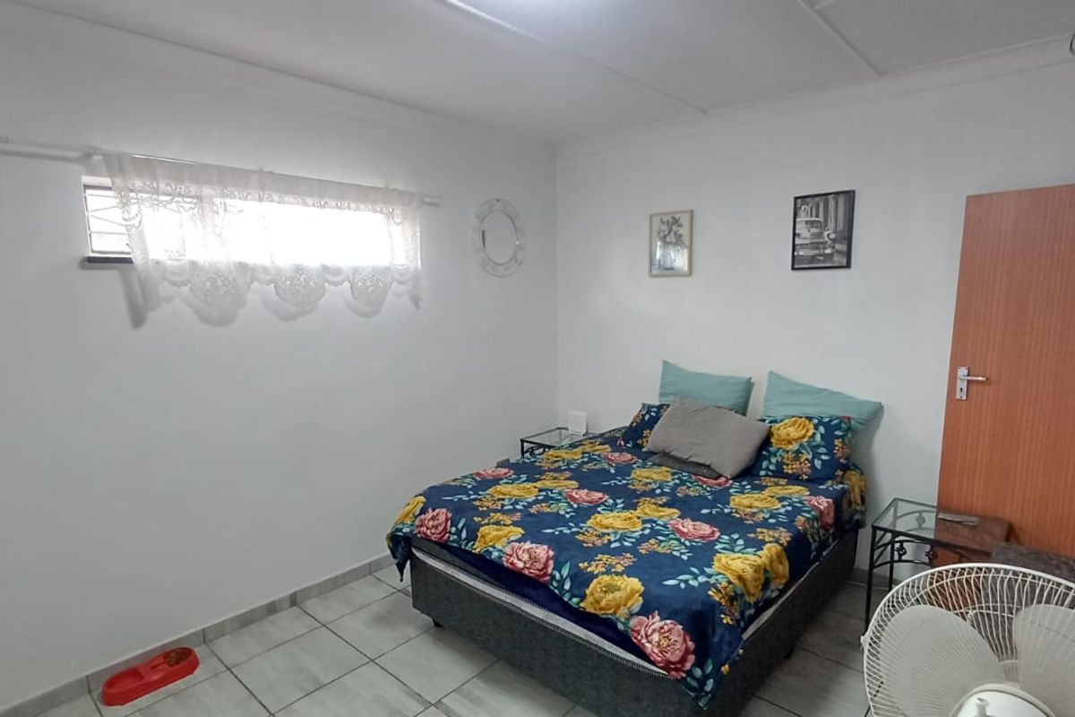 A functional bedroom featuring tiled flooring, a horizontal window, and a standard timber door, providing a simple and practical living space.