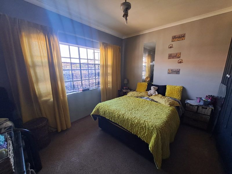 A standard bedroom featuring a window with natural light, coving, and a built-in wardrobe, offering a functional space for rest.