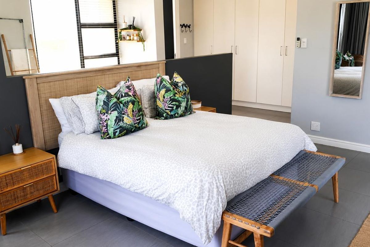 A well-maintained bedroom featuring neutral wall tones, tiled flooring, and ample built-in cupboard storage space.