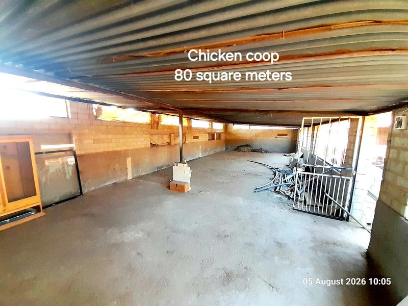 A large 80 square meter utility space featuring concrete flooring, brick walls, and a corrugated metal roof, suitable for agricultural or storage purposes.