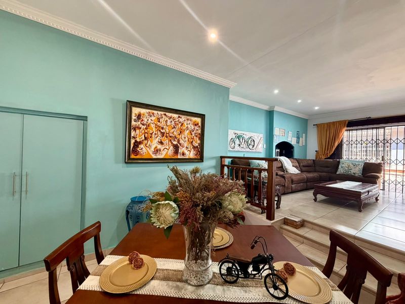 Open-plan living and dining area featuring split-level flooring, tiled surfaces, recessed lighting, and built-in storage cupboards.