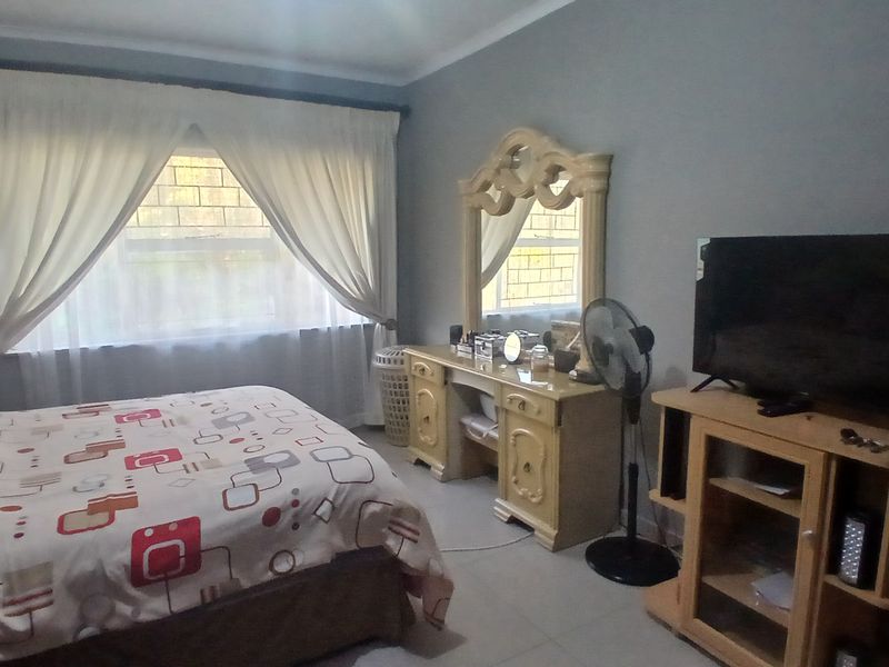 A standard bedroom featuring tiled flooring and window treatments, offering a functional space ready for personal updates.