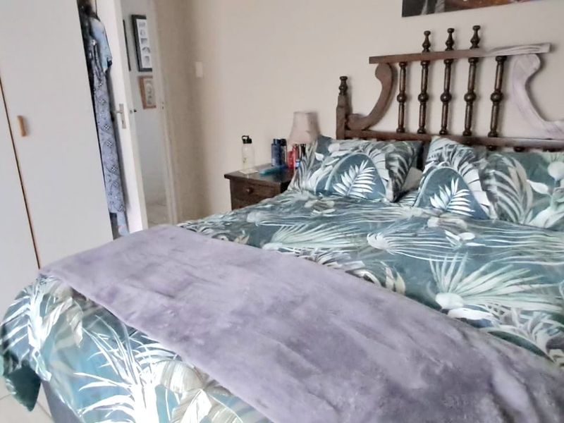 A bedroom featuring built-in cupboards and tiled flooring, providing a functional living space.