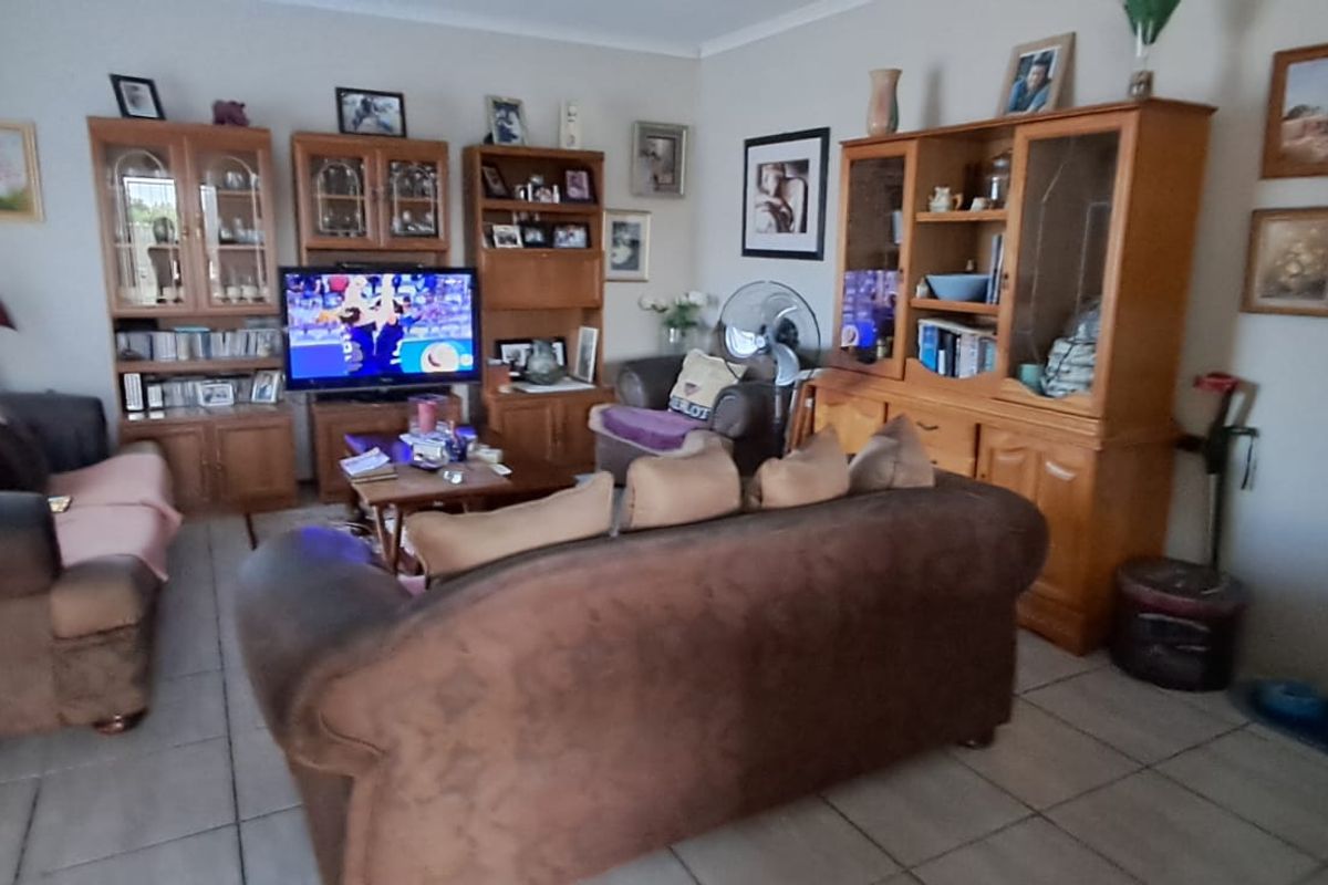 A living room featuring tiled flooring and coved ceilings, providing a functional space for relaxation and entertainment.