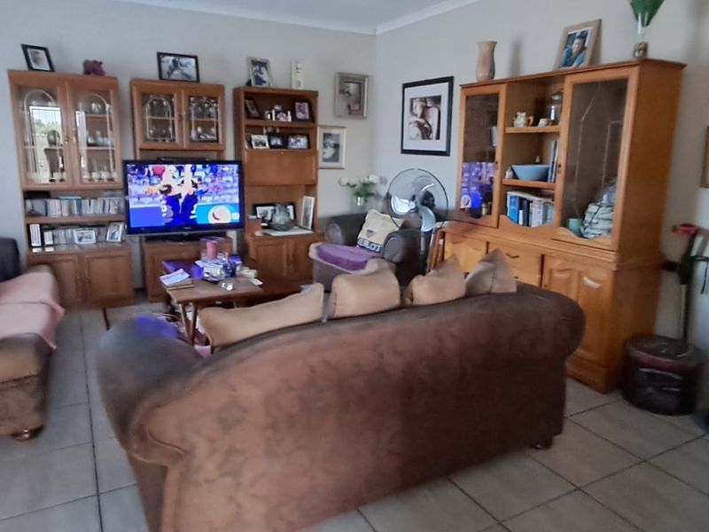 A living room featuring tiled flooring and coved ceilings, providing a functional space for relaxation and entertainment.