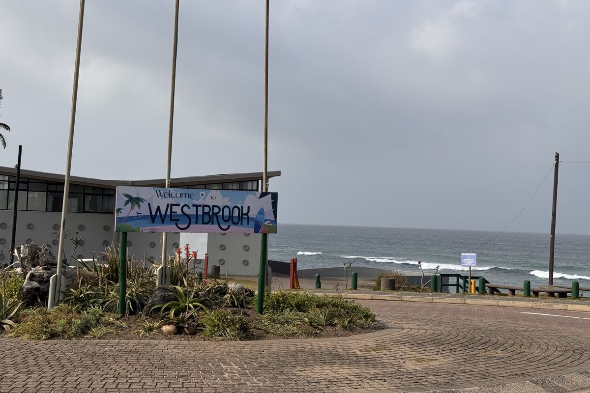 A view of the Westbrook area entrance featuring a paved roundabout, signage, and coastal ocean views in the background.