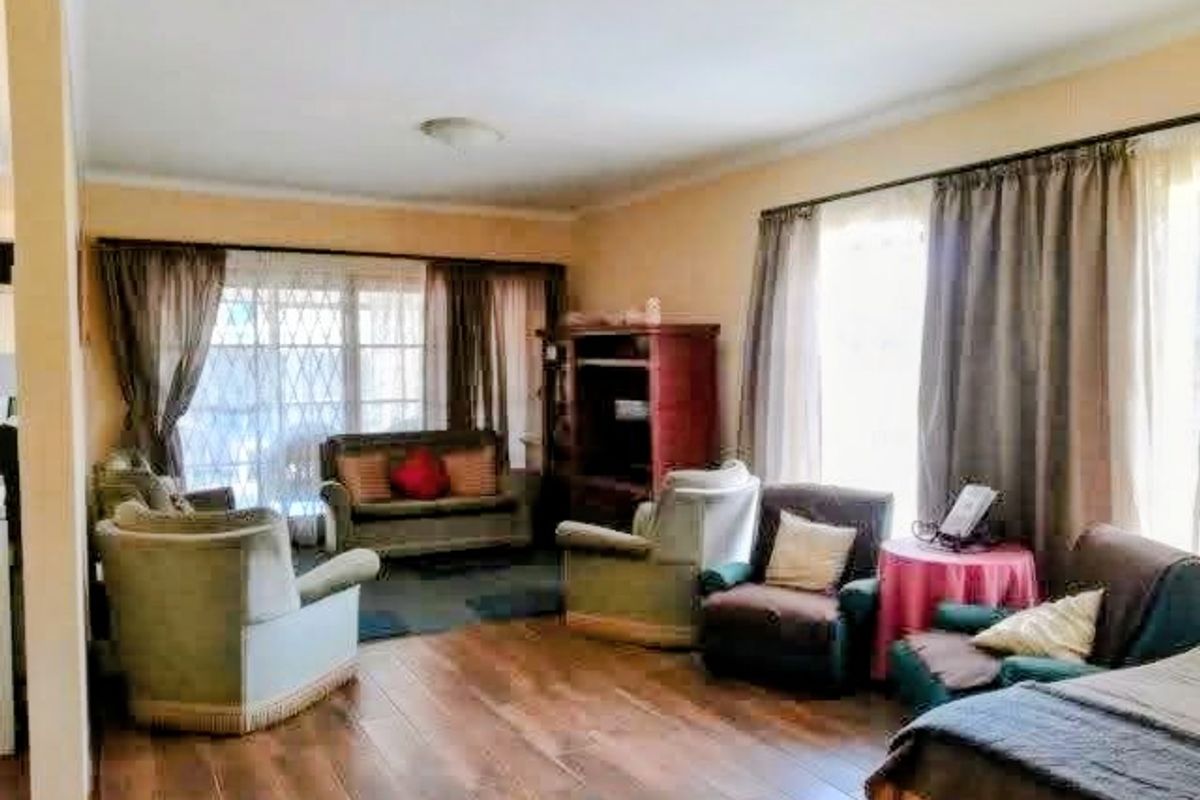 A spacious living room featuring wood-look tile flooring and large sliding glass doors that provide ample natural light.