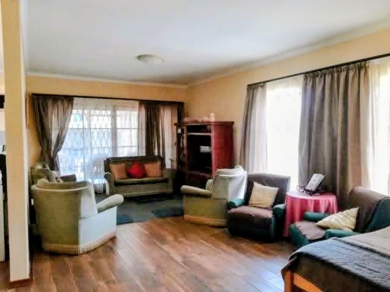 A spacious living room featuring wood-look tile flooring and large sliding glass doors that provide ample natural light.