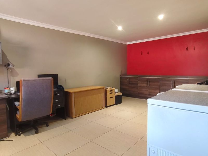A functional utility space featuring tiled flooring, recessed lighting, and built-in cabinetry, offering versatile storage or workspace potential.