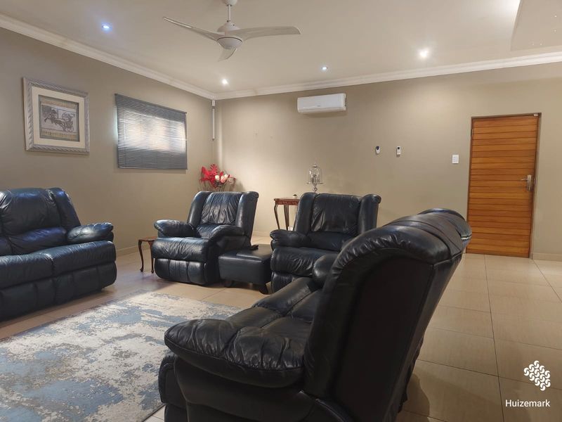 Spacious living room featuring tiled flooring, recessed lighting, a ceiling fan, and a wall-mounted air conditioning unit.