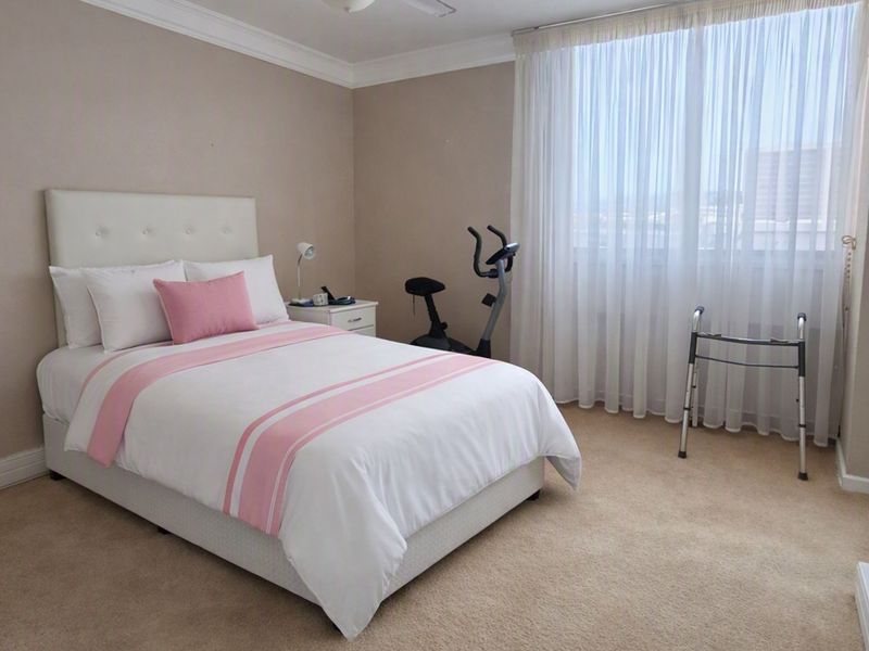 A well-maintained bedroom featuring neutral wall tones, carpeted flooring, decorative ceiling coving, and a wall-mounted television.