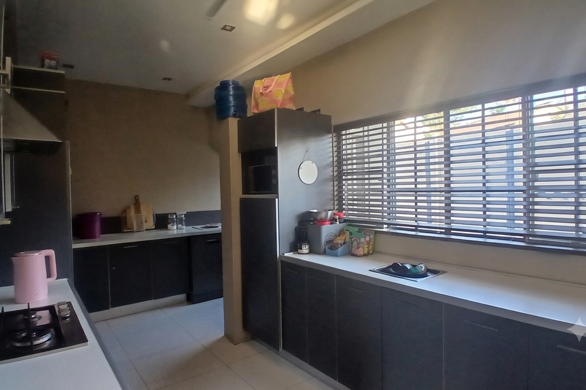 Modern kitchen featuring dark cabinetry, white countertops, a gas cooktop, built-in oven, and large windows with venetian blinds providing ample natural light.