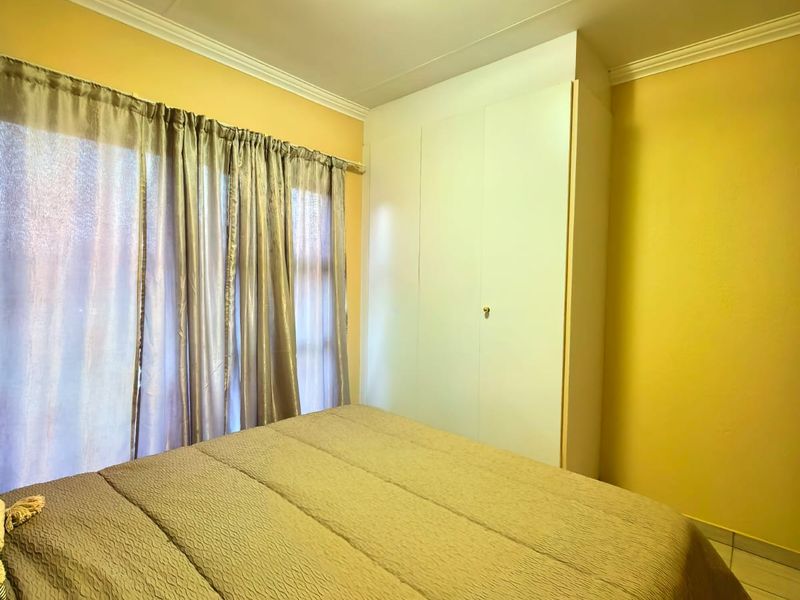 A bedroom featuring tiled flooring, a built-in wardrobe, and a ceiling light fixture, finished with decorative coving.