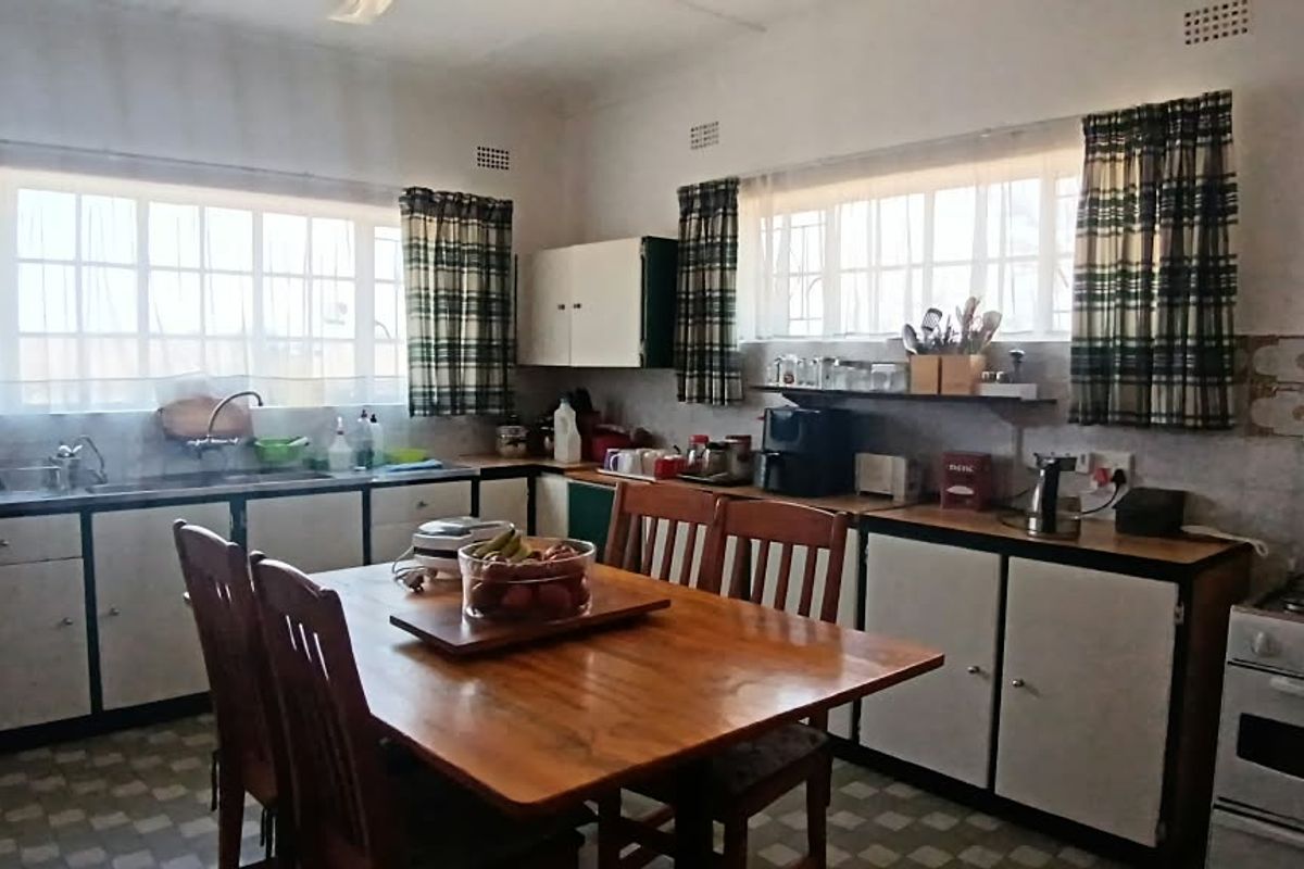 A functional, dated kitchen featuring built-in cabinetry, a gas stove with oven, and tiled backsplash, offering potential for modernization and renovation.