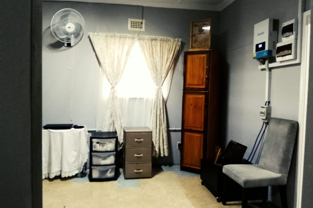 A functional bedroom space featuring a wall-mounted fan, ventilation, and integrated electrical infrastructure including an inverter and distribution board.