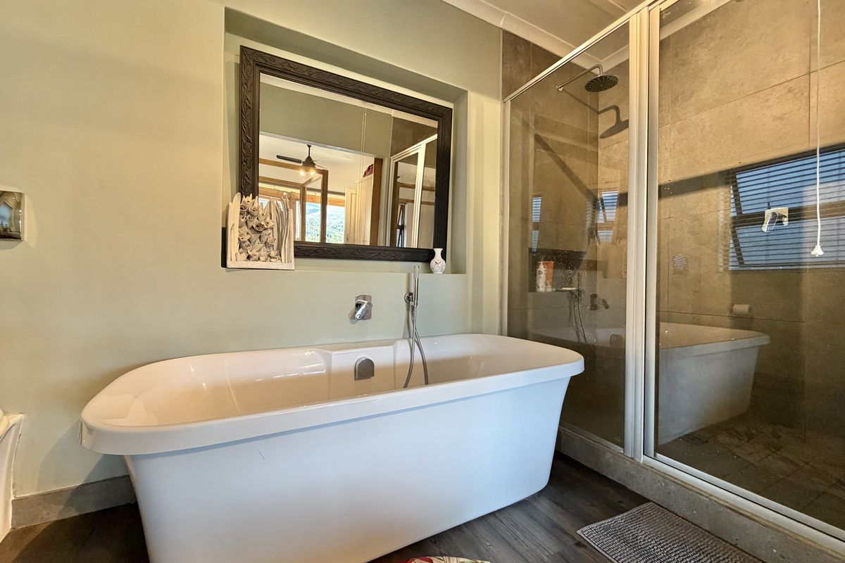 A modern bathroom featuring a freestanding bathtub, a separate walk-in shower with tiled walls, and a recessed mirror above the tub.