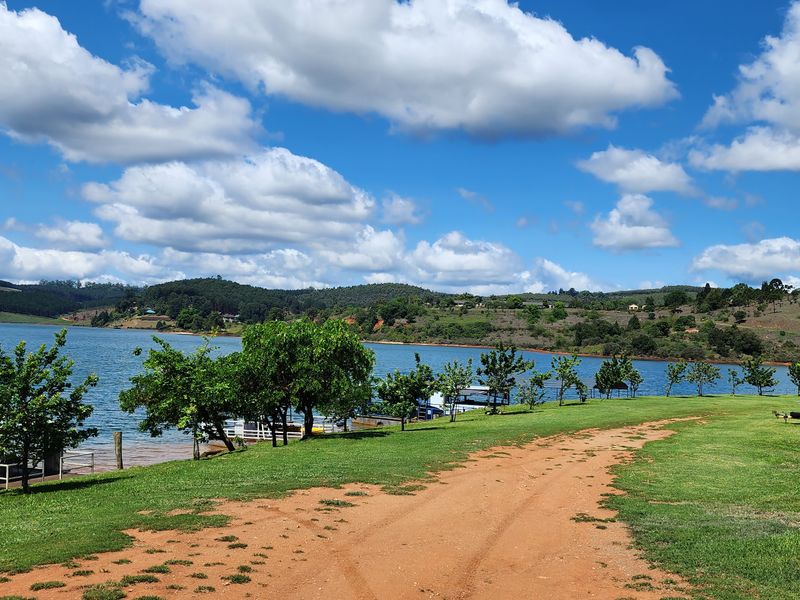 A scenic view of the waterfront featuring a grassy landscape and natural surroundings, ideal for residential development.