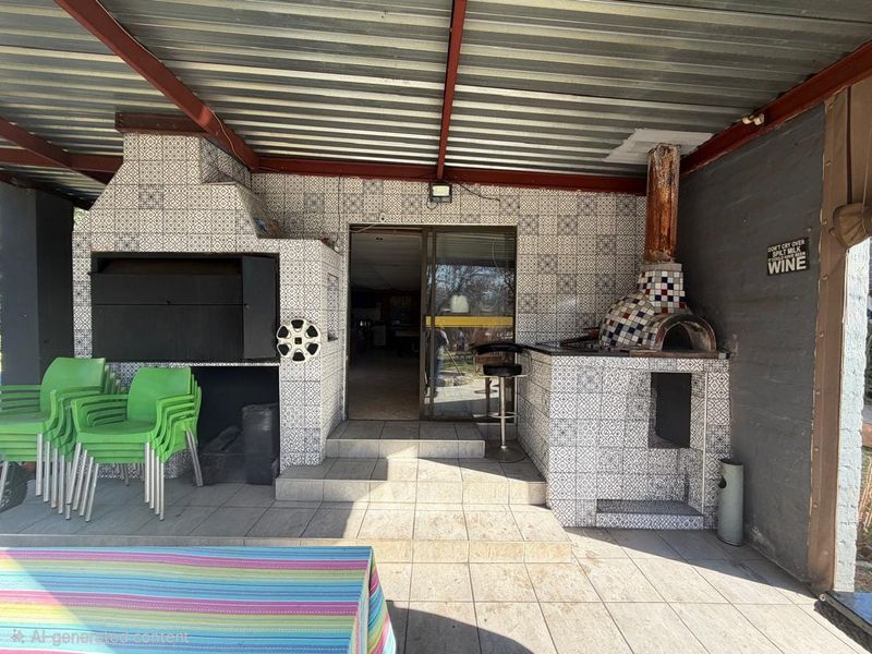 Covered outdoor entertainment area featuring a built-in braai, pizza oven, and tiled flooring with direct access to the interior living space.