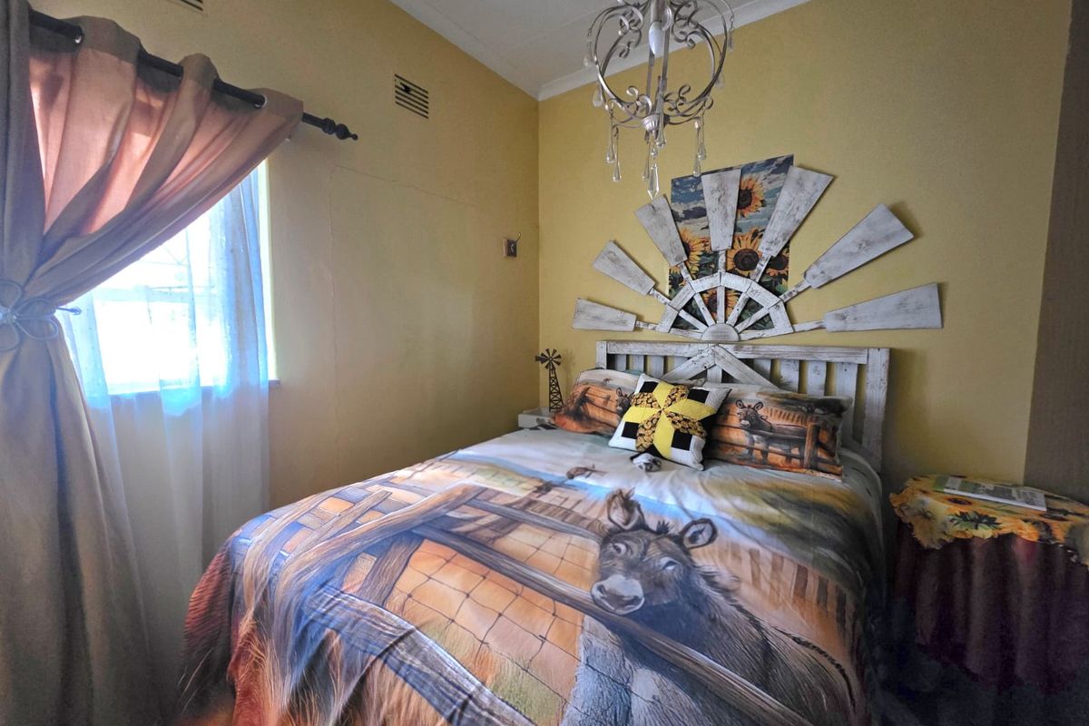 A bedroom featuring yellow walls, a decorative ceiling chandelier, and wall ventilation grilles.