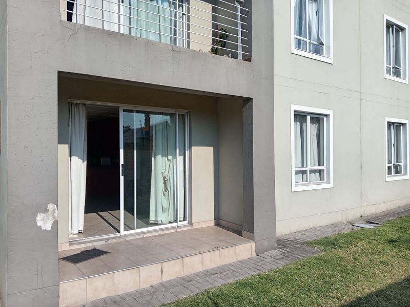 Ground floor patio area with tiled flooring and sliding glass door access, featuring an adjacent paved walkway and exterior wall finish.