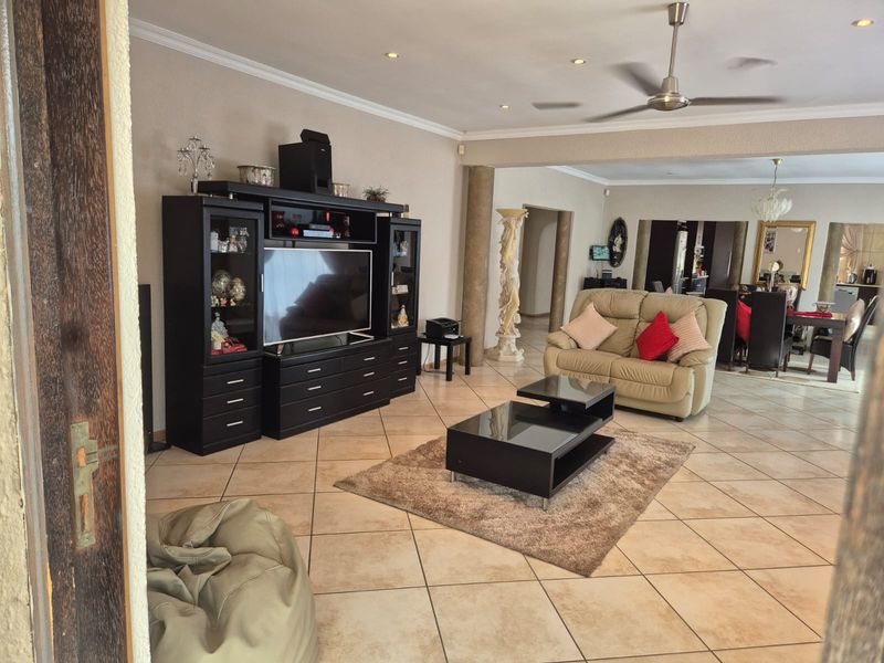 Spacious open-plan living area featuring tiled flooring, recessed lighting, and a ceiling fan, creating a versatile space for relaxation and dining.
