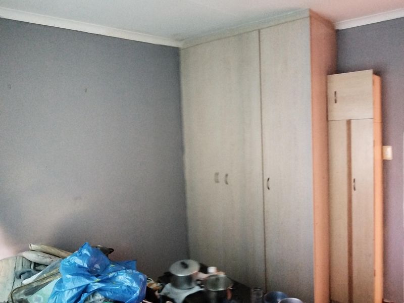 A bedroom featuring built-in wooden cupboards, providing ample storage space within the room.