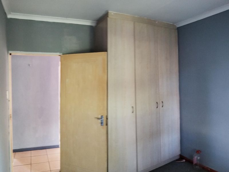 A bedroom featuring a built-in wardrobe and neutral wall tones, offering a blank canvas for potential interior updates.