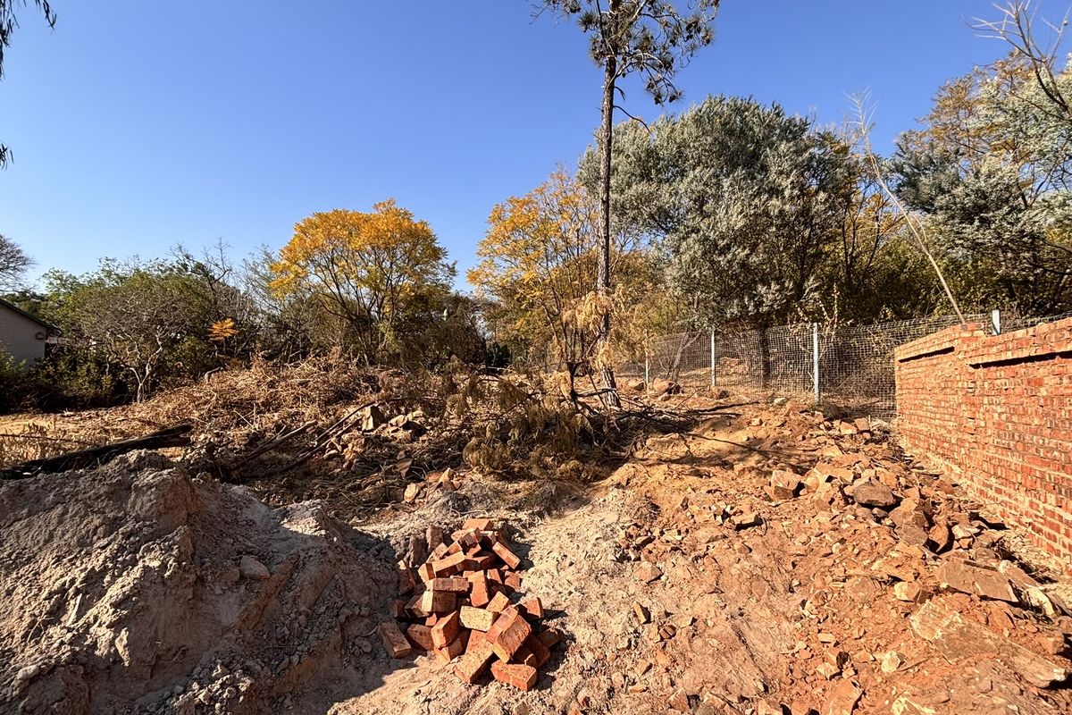 A large, undeveloped garden area featuring a brick boundary wall and wire fencing, currently requiring significant landscaping and site clearing.