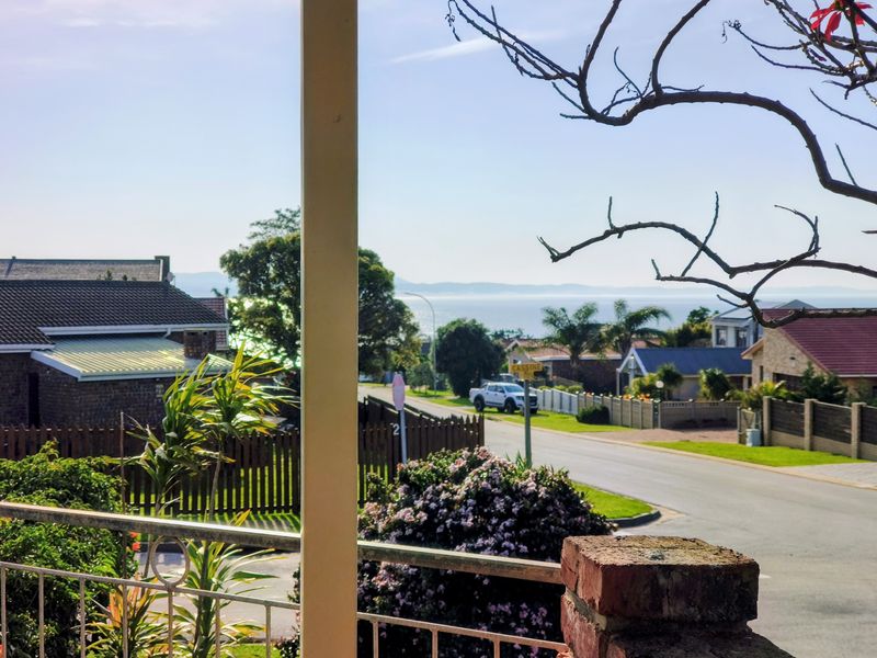 A scenic view of the surrounding neighbourhood and distant coastline captured from an elevated balcony.