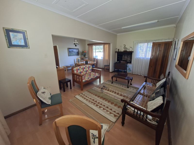 Open plan living and dining area featuring laminate flooring, a built-in fireplace, and direct access to adjacent living spaces.