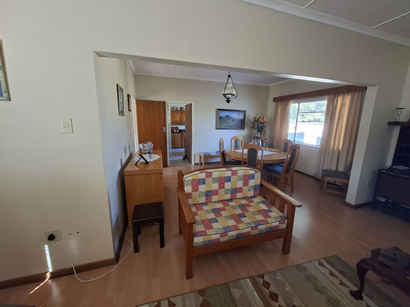 Open plan living and dining area featuring laminate flooring and neutral wall tones, with direct access to the adjacent kitchen area.