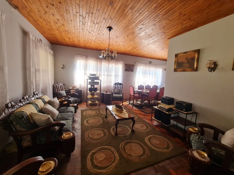 Spacious open-plan living and dining area featuring warm timber tongue and groove ceilings and classic parquet flooring throughout.