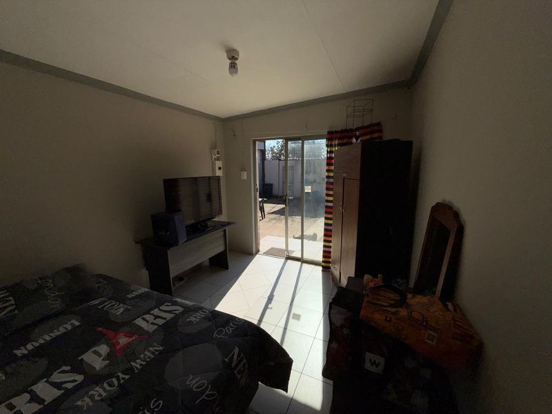 A bedroom featuring tiled flooring and a sliding glass door providing direct access to the outdoor area.