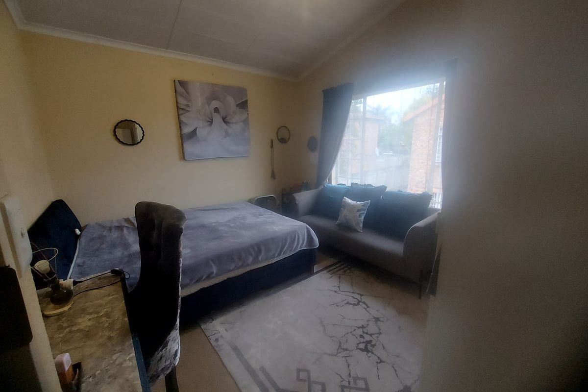 A bedroom featuring a large window that provides natural light, with neutral wall finishes and a coved ceiling.