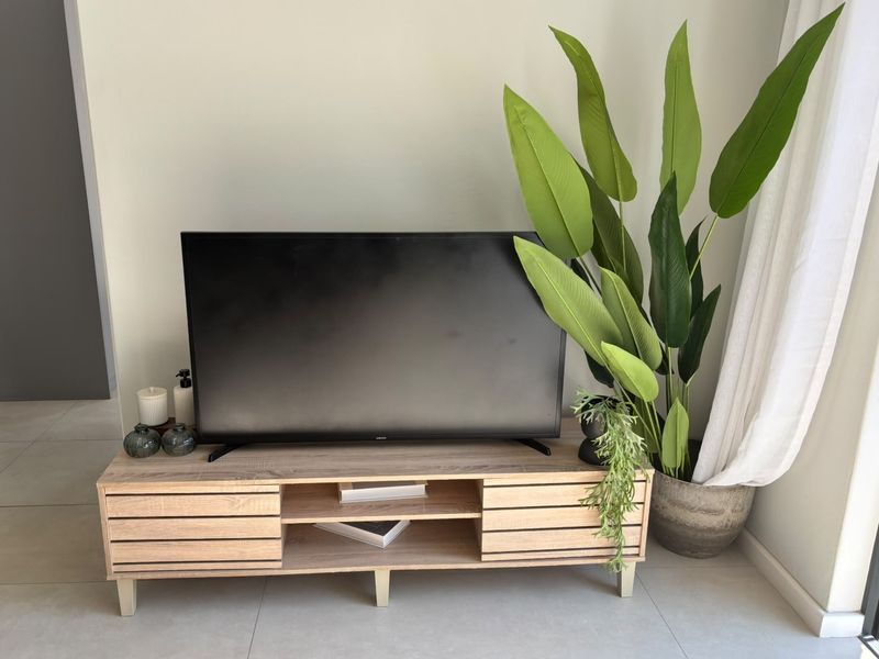 A bright living room area featuring neutral tiled flooring and a clean, modern aesthetic.