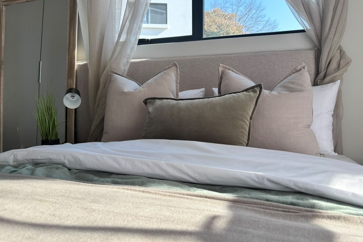 A well-lit bedroom featuring a large window and built-in wardrobe, creating a bright and comfortable sleeping space.