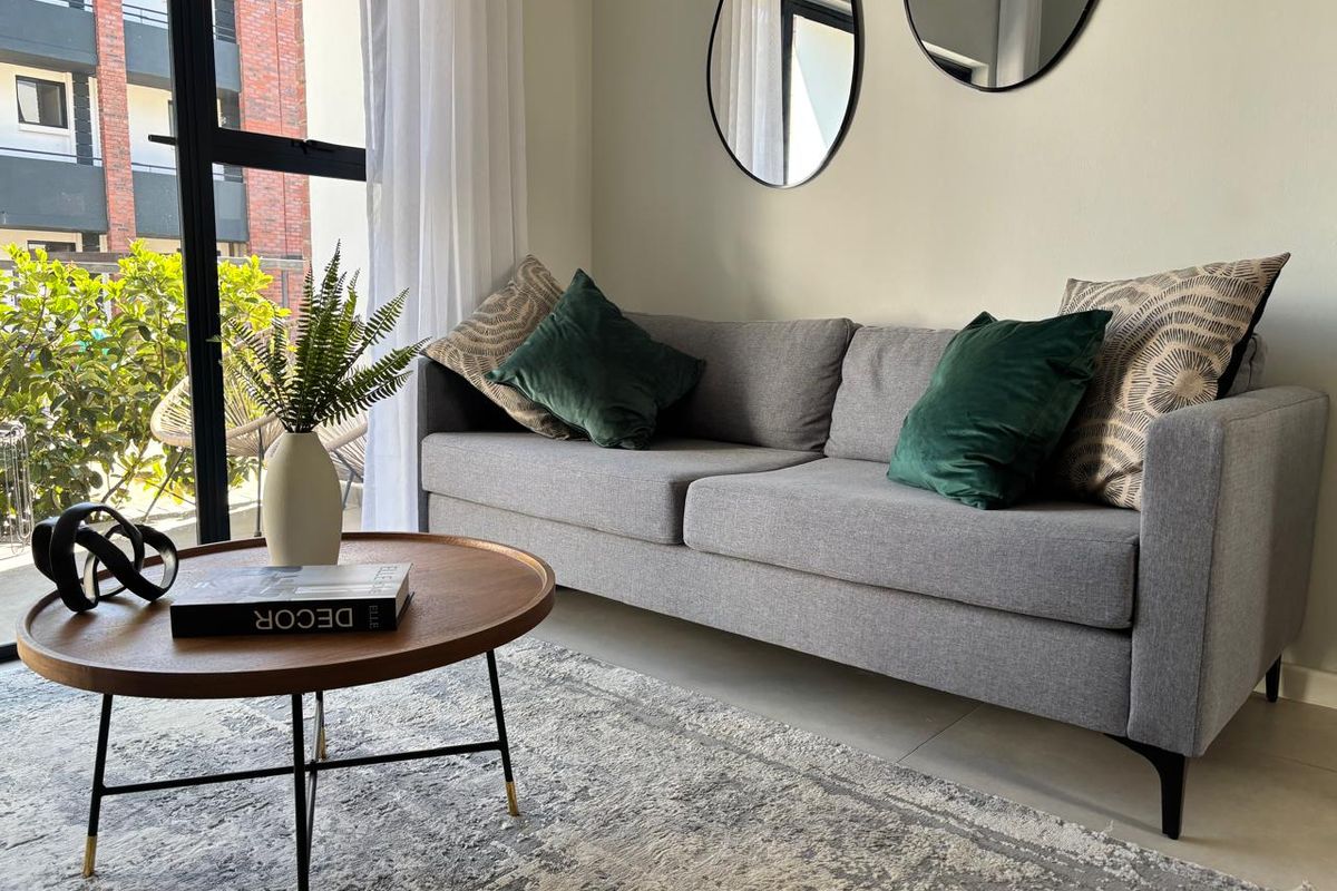 A bright living room featuring large glass sliding doors that provide natural light and access to an outdoor balcony area.