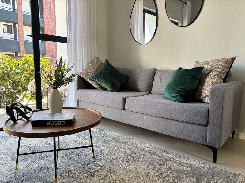 A bright living room featuring large glass sliding doors that provide natural light and access to an outdoor balcony area.