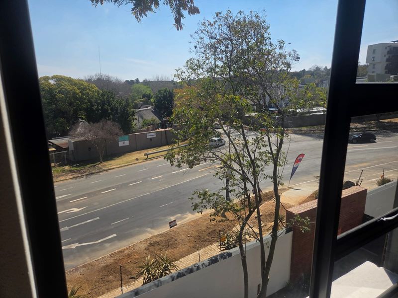 A view from an apartment window overlooking a suburban street and surrounding neighbourhood.