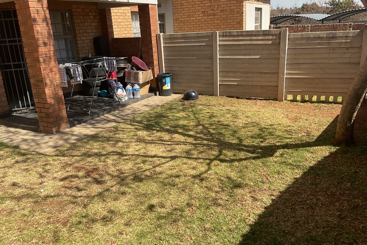 A private rear garden featuring a covered brick patio area and a precast concrete boundary wall.