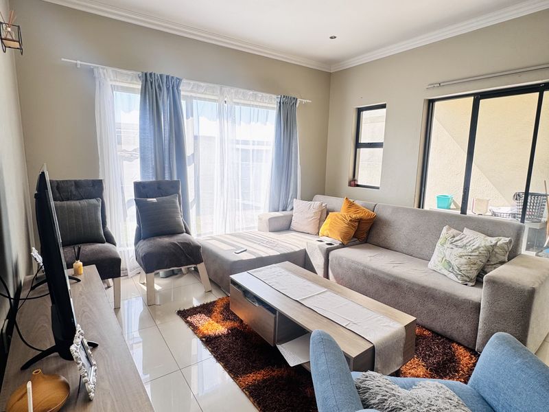 A bright and spacious living room featuring large sliding glass doors that provide natural light and access to the outdoor area.