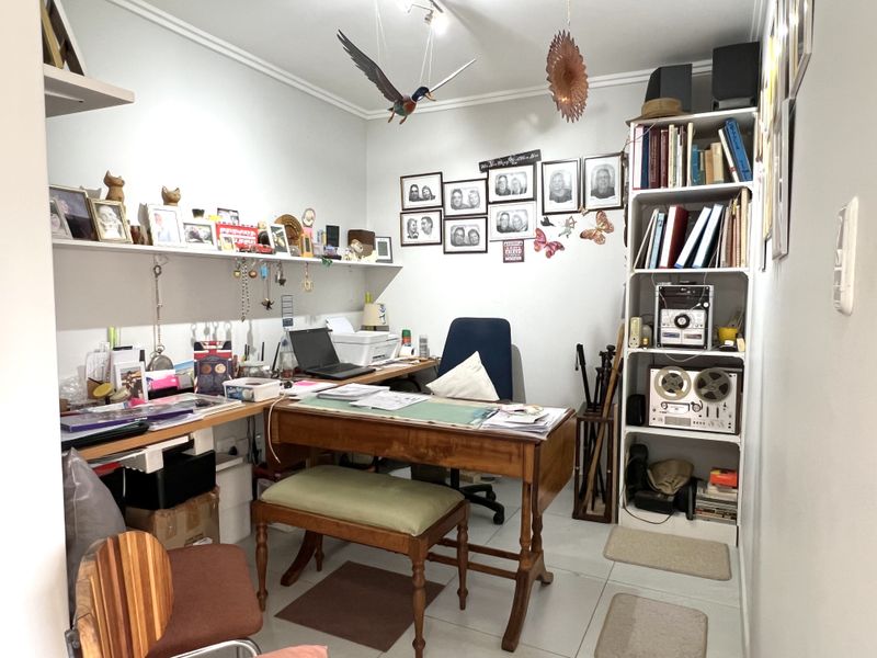 A functional home office space featuring built-in wall shelving and tiled flooring, providing a dedicated area for work or study.