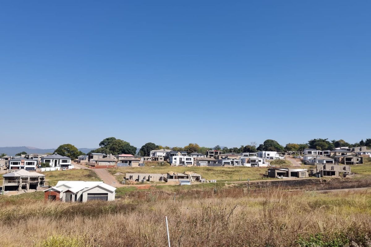 An elevated view of a residential estate under development, featuring multiple homes in various stages of construction amidst open land.