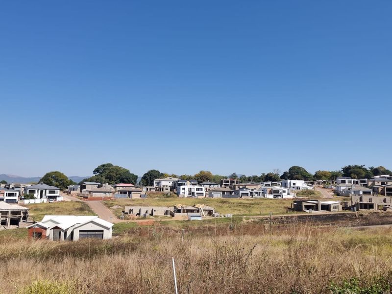 An elevated view of a residential estate under development, featuring multiple homes in various stages of construction amidst open land.