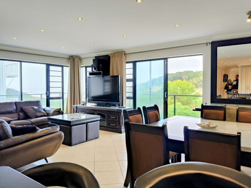 Spacious open-plan living and dining area featuring large sliding glass doors that provide natural light and access to the balcony.